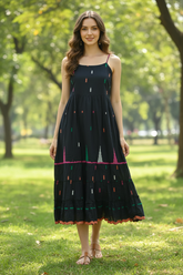 Model in black cotton singlet dress at park