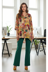 Model wearing floral tunic with bottle green flared pants in office