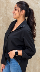 Side profile of black shirt showing the collar dragonfly motif and two-button cuff