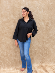 Black dragonfly handwork shirt worn untucked with light blue flared jeans