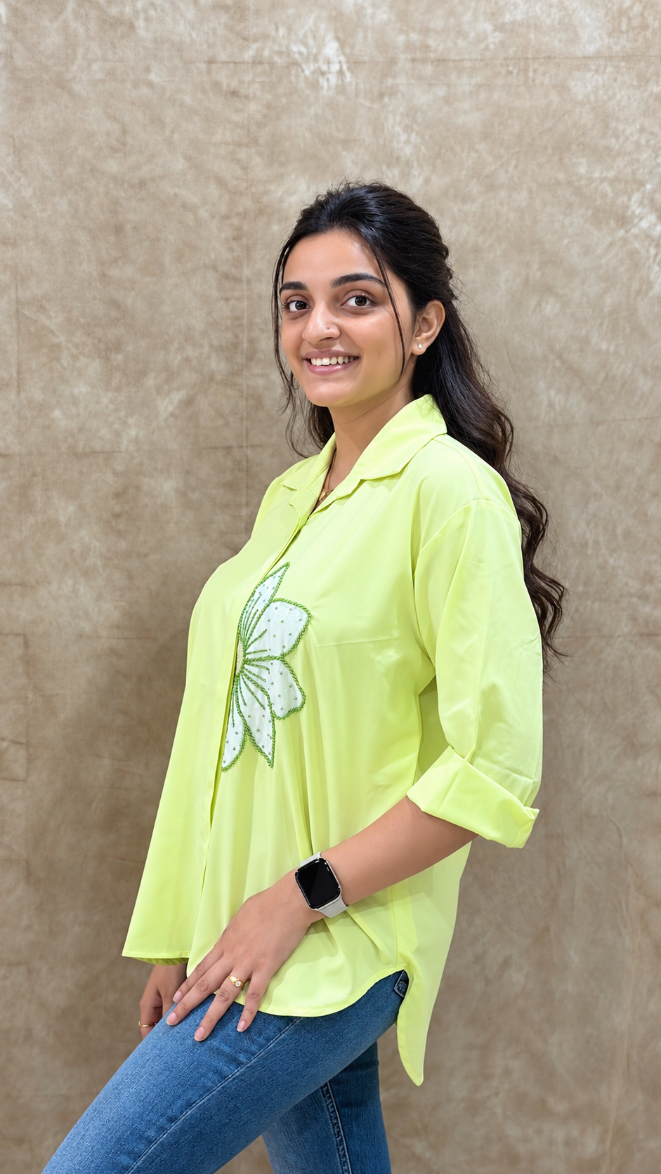 Side view of lime green shirt showing the apple blossom handwork motif and rolled sleeves