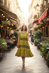 Model in yellow-green dress walking on cafe street
