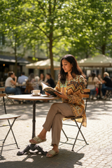 Model wearing brown linen pants at café
