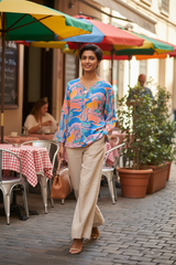 Model wearing geometric top in street café